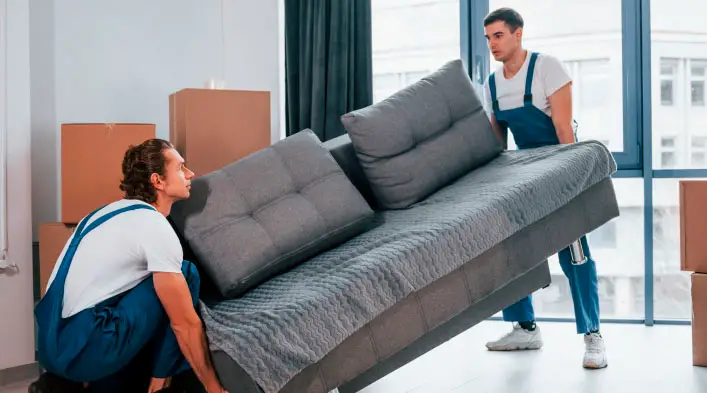 Professional furniture removalists carrying a sofa in Sydney