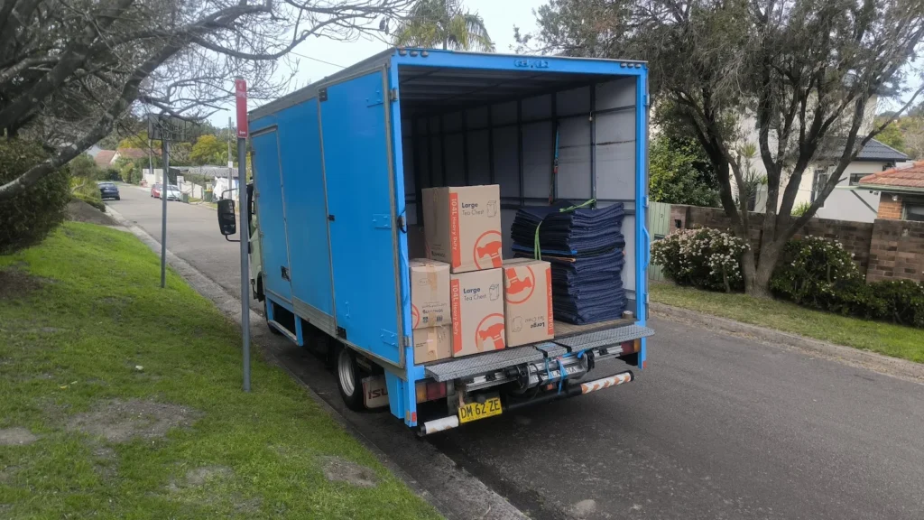 Grey Whales Removals moving truck loaded with boxes and moving blankets on a Sydney street